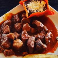 Adobo De Puerco · Marinated cubes of pork topped with a thick spicy red sauce made of tomato, ancho, and chili...