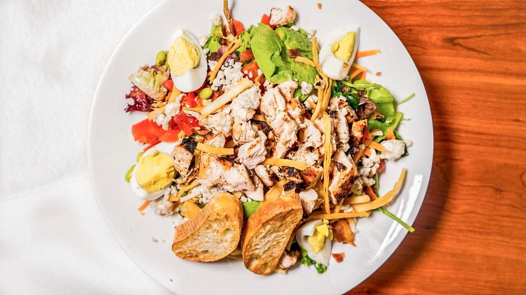 Eggspectation Chop Salad · Mixed greens tossed in our chianti basil vinaigrette with diced tomatoes, crumbled bacon, roasted corn, edamame, Bleu cheese crumbles, shredded carrots, and diced grilled chicken topped with crispy tortilla strips, sliced hardboiled egg and avocado.