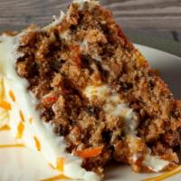 Carrot Cake · Rich and moist carrot cake with raisins and crushed walnuts, iced in a cream cheese frosting.
