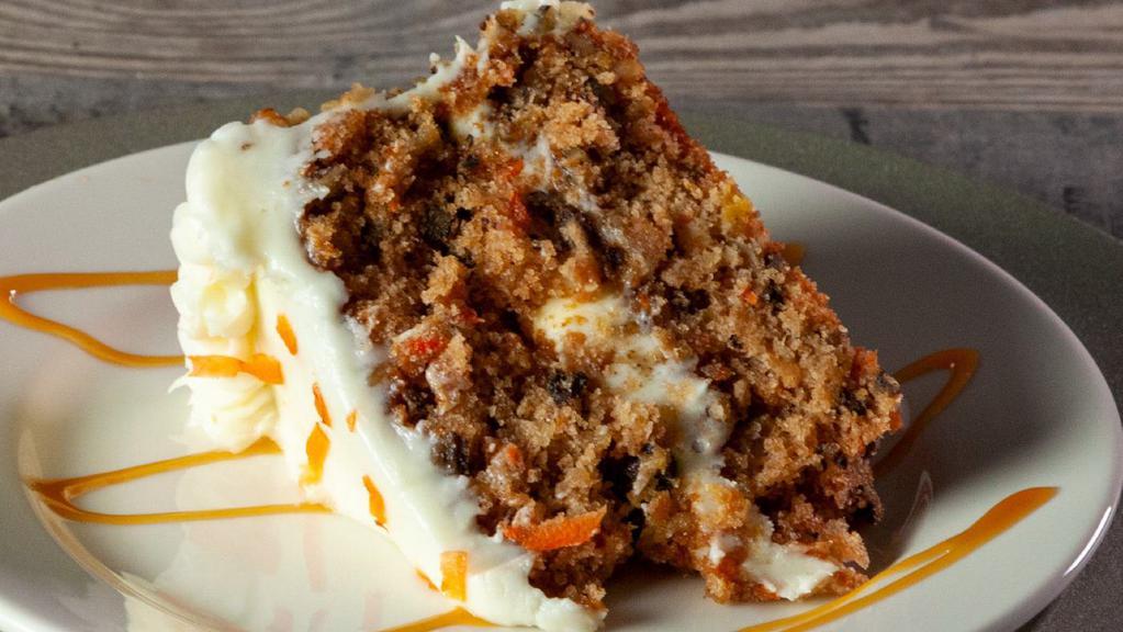Carrot Cake · Rich and moist carrot cake with raisins and crushed walnuts, iced in a cream cheese frosting.