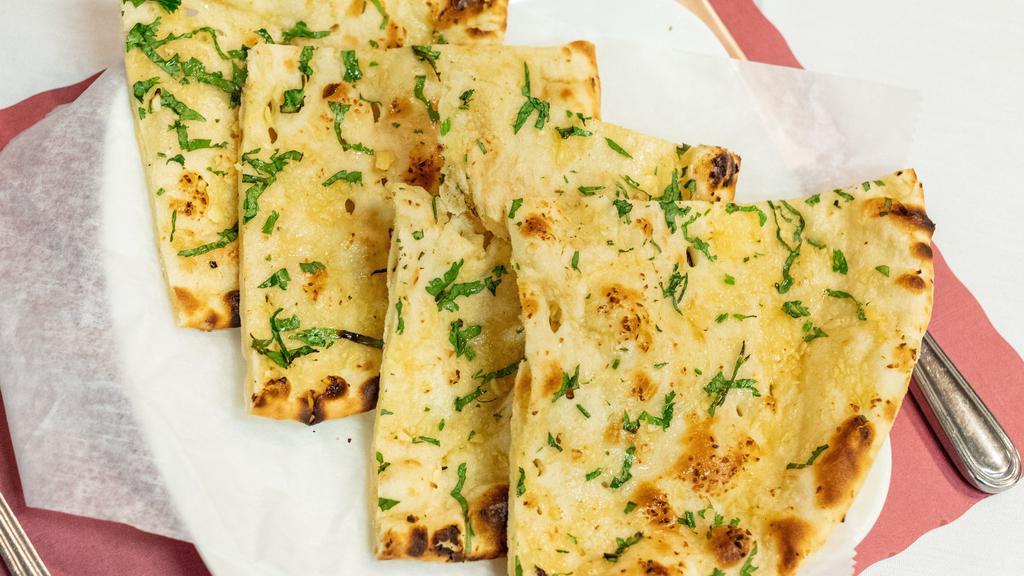 Garlic Naan · A popular, aromatic naan topped with fresh chopped garlic and spices.