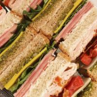 Club Sandwich · Turkey, ham, bacon, swiss and American cheese, mayo, pesto lettuce, tomato on wheat bread.