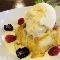 White Chocolate Bread Pudding · Brioche bread soaked in a rich white chocolate sauce, served warm with coconut sauce and van...
