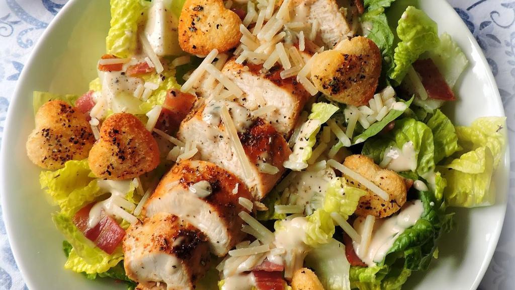 Grilled Chicken Caesar Salad · Grilled boneless breast of chicken served on a bed of romaine lettuce with croutons, Parmesan cheese and caesar dressing.