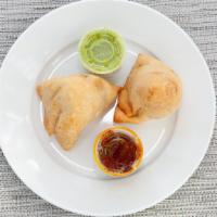Samosa - Veggie (V) · Vegetarian. Seasoned potatoes and green peas wrapped in a crispy puff pastry. Served with gr...