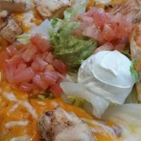 Chicken Fajita Nachos · (Layered with refried beans). Served with guacamole, sour cream, tomatoes and jalapenos.