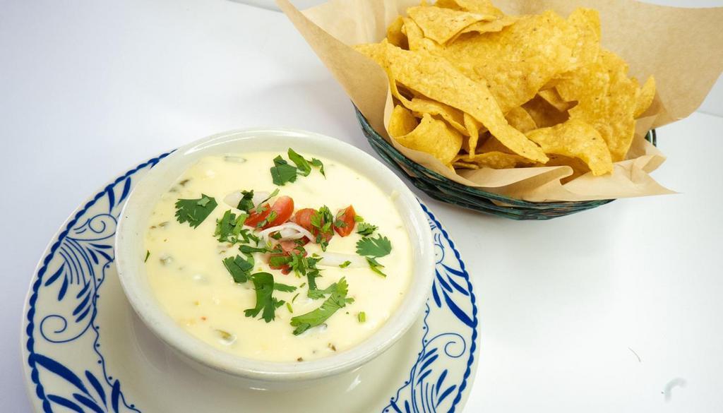 Queso Poblano · melted chihuahua cheese, pepper jack, queso blanco, diced roasted poblano peppers, nopales, fresh corn.