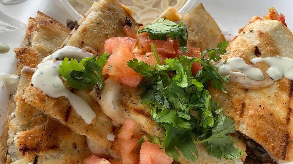 Laura'S Pollo Loco Quesadilla · The unassuming quesadilla that fits the budget and takes you to a happy place. Made with shredded chicken breast, street cheese, bacon bits, sauteed onions, light sriracha, and a ranch drizzle. Topped with cilantro creama and pico de gallo.