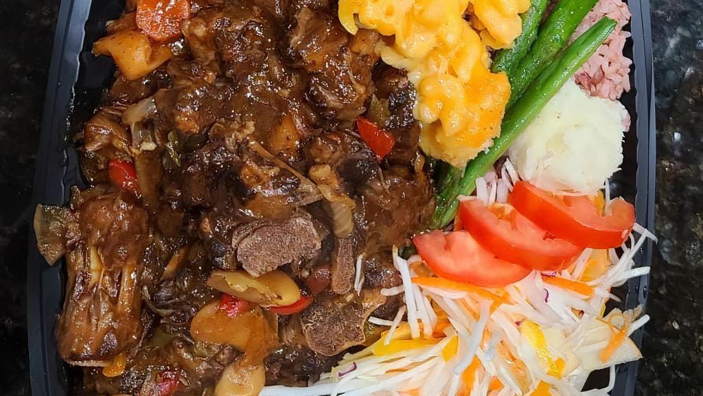 Oxtail · Braised oxtails simmered for 4 hours with carrot onion, bell pepper, butter beans and a hint of scotch bonnet pepper sever with 2 sides of your choices