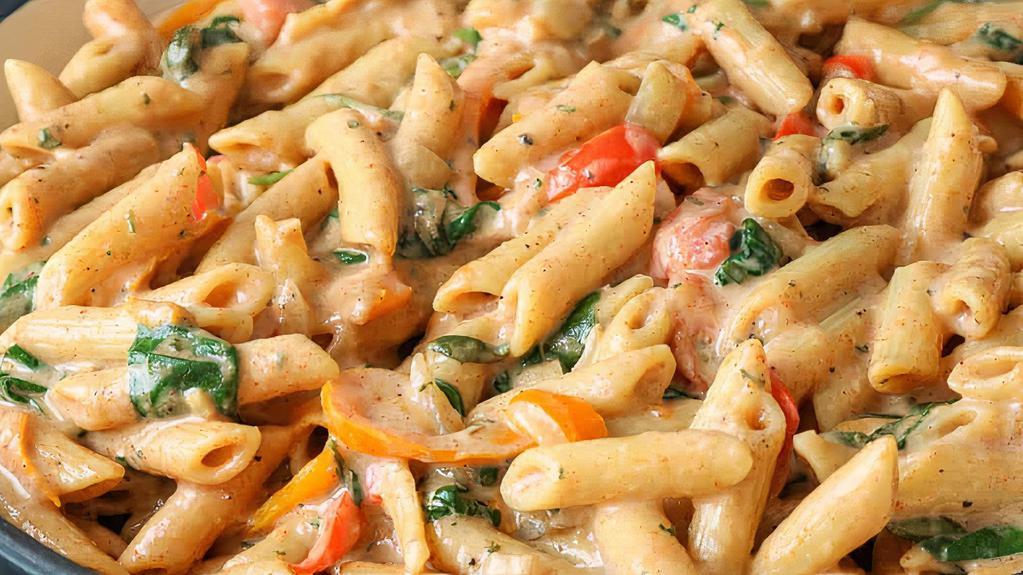 Rasta Pasta · Penne pasta in a creamy coconut basil sauce with chicken