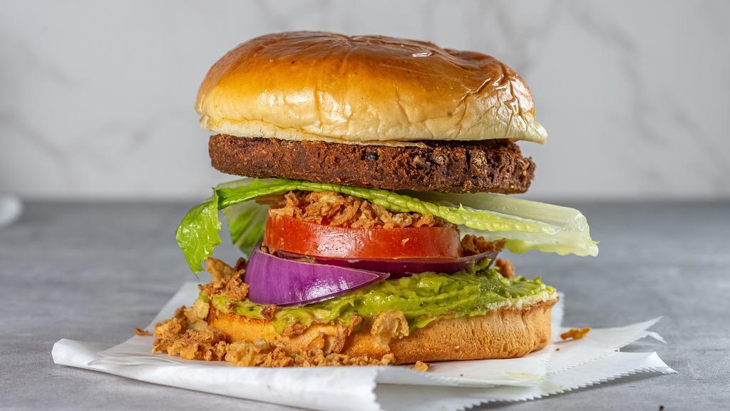 Bean Queen Veggie Burger · Vegan. Black bean patty, crushed fried onions, avocado sauce, lettuce, tomato and onions.