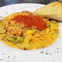 Tortellini Bolognese · Cheese tortellini pasta cooked in our delicate meat pink creamy sauce