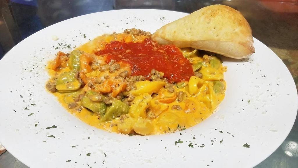 Tortellini Bolognese · Cheese tortellini pasta cooked in our delicate meat pink creamy sauce