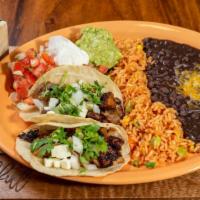 Roasted Pork Taco · Two corn tortillas stuffed with pork, onions, cilantro and cotija cheese. Served with rice a...