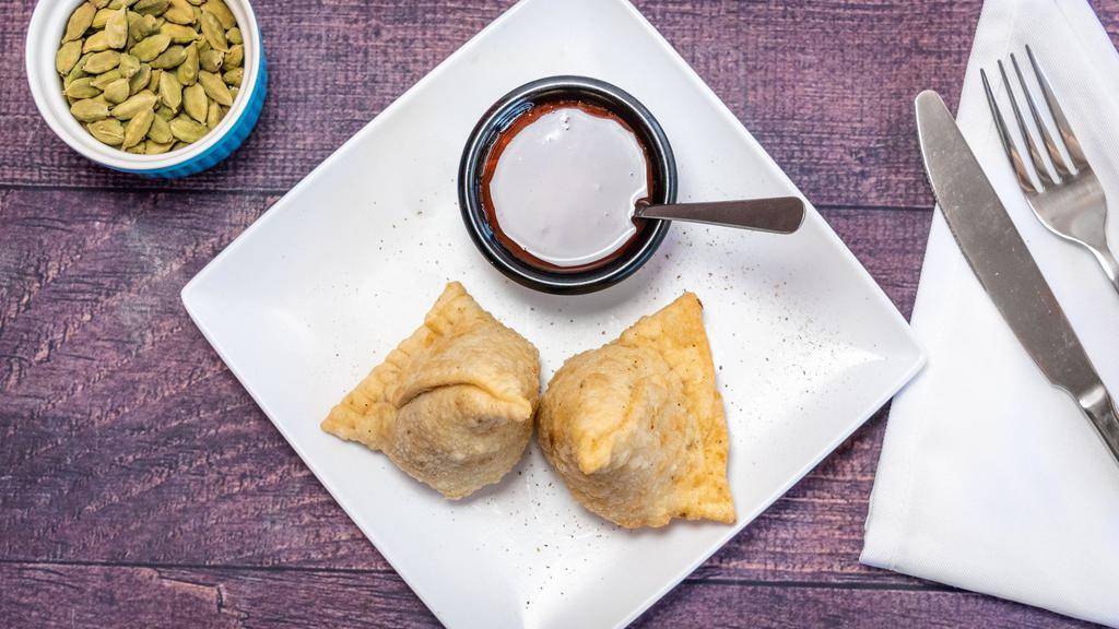 Fresh Vegetable Samosa · Two pieces. Two samosas filled with spiced potato, green peas wrapped in a thin layer of flour dough and fried crisp. Served with tamarind sauce.