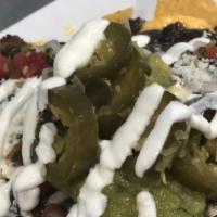 Mexican Nachos Chamacos · Fried tortilla chips with refried beans, tomato, jalapeños, topped with melted shredded chee...