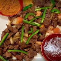 Loza'S Tibs · Thin sliced beef stir fried with onions, green pepper and tomatoes.