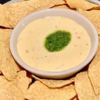 Chips & Queso · Fresh daily made Queso serve with tortilla chips and a  cilantro chutney.