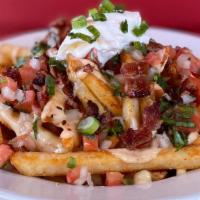 Stoner Snack · Spicy fries topped w/Queso, pico de gallo, bacon, sour cream and green onions.