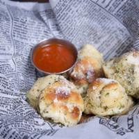 Garlic Knots · Freshly baked homemade dough, tossed in garlic, olive oil and parmesan.