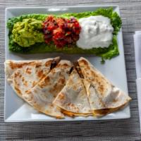 Quesadillas · Tex-Mex tortilla stuffed with cheese and topped with guacamole and pico de gallo.