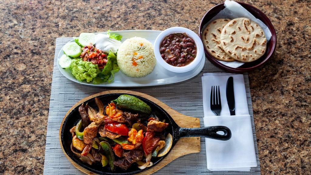 Sizzling Fajitas · All fajitas are grilled to perfection over a bed of sauteed green peppers and red onions, served with rice, beans, pico de gallo, sour cream and guacamole.