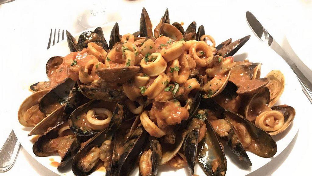 Seafood Paella · Saffron orzo, mixed shellfish, and light tomato broth