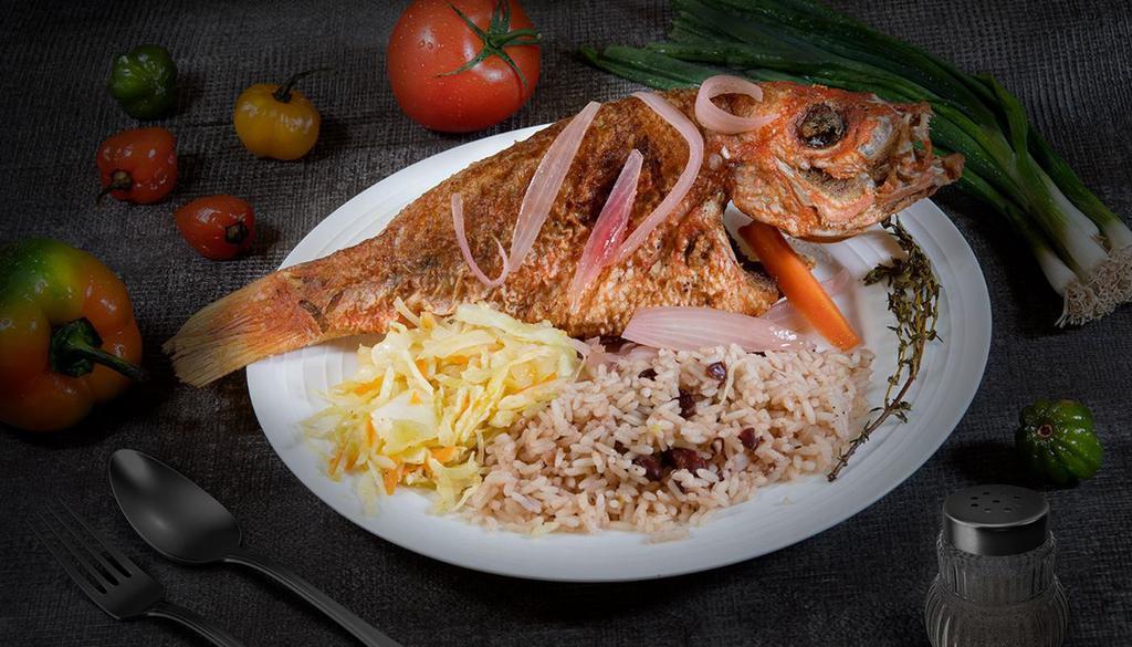 Escovitched Snapper( Vinegar Style) · Whole Snapper that is fried and then stewed in a vinegar based sauce with onions, green peppers and carrots served with rice & peas and a side of cabbage