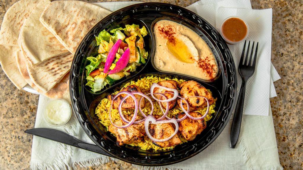 Chicken Kabob · Marinated chicken breast grilled on a skewer. Served with rice, salad, hummus, and pita bread.