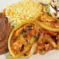 Pollo Encebollado · Sauteed chicken strips with onions accompanied with rice, refried beans, and salad.