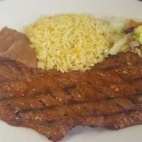 Carne Asada · Broiled Salvadoran style steak accompanied with refried beans, rice, and salad.