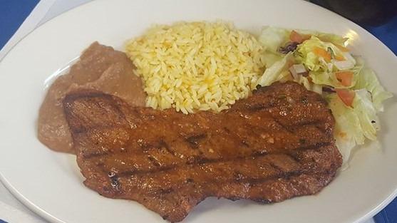 Carne Asada · Broiled Salvadoran style steak accompanied with refried beans, rice, and salad.