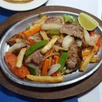 Lomo Saltado De Res · Strips of grilled Steak sauteed with onion, tomato, carrot, green peppers with steak fries a...