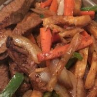 Lomo Saltado · Strips grilled pork sautéed with onion, tomato, green pepper with steak fries accompanied wi...