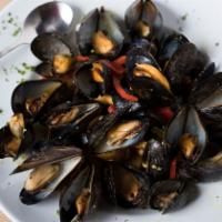Moules Marinières · Large plate of black mussels in a white wine, green&red peppers and saffron garlic sauce.