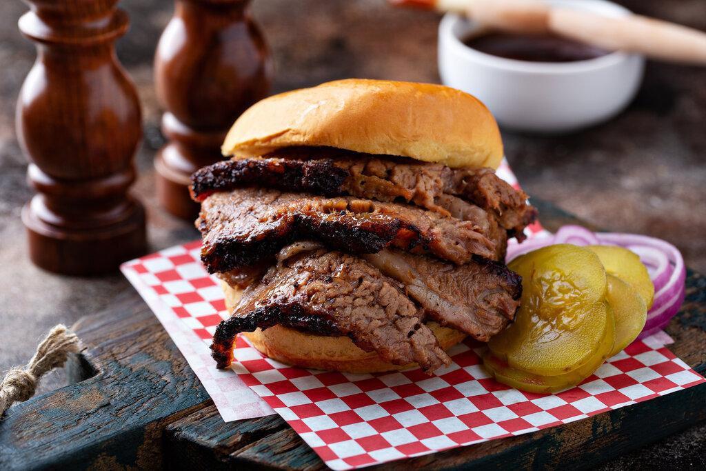 Sliced Beef Brisket Sandwich · Angus Beef Brisket smoked slow and low, sliced, and served on toasted bread with house made pickles and our signature BBQ sauce.