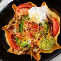 Taco Salad · Flour tortilla shell filled with romaine lettuce, tomatoes, onions, avocado, beans, sour cre...