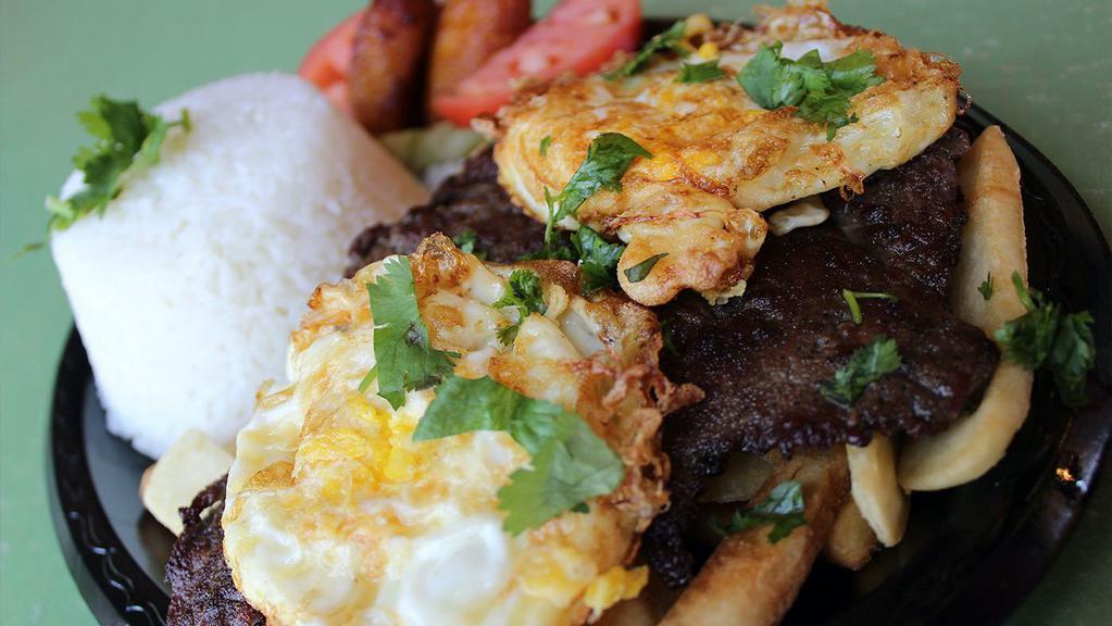 Bistec A Lo Pobre · Grilled marinated steak served with two sunny sides up eggs. French fries, rice, and plantain.