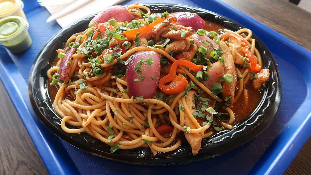 Tallarin Saltado · Peruvian dish made with spaghetti sautéed with tender chicken, red onions, tomatoes, peppers and herbs,
