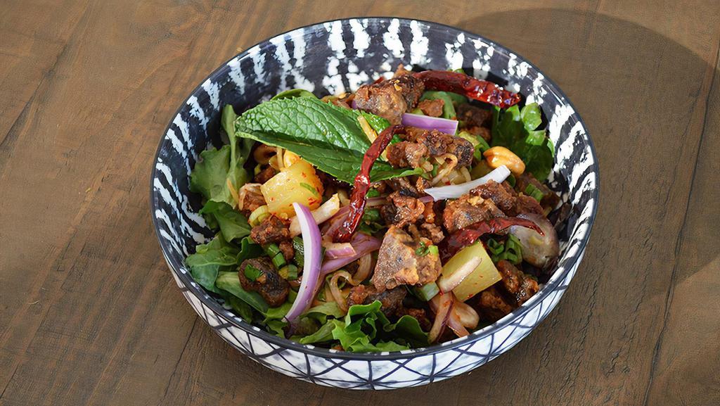 Crispy Duck Salad · Crispy duck mixed with fresh lime juice, ginger, red onion, cilantro, chili paste, chunk pineapple, dry chili and cashew nuts.