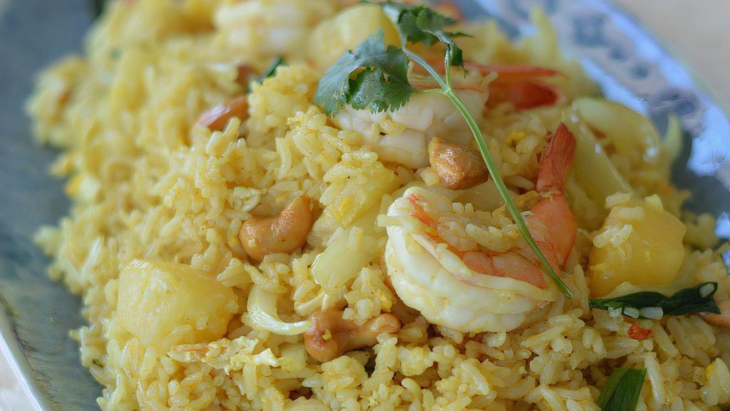 Pineapple Fried Rice · Jasmine rice, shrimp, chicken, scallions, pineapple, curry powder, onion, cashew nut and egg. Top off with a garnish of cilantro.