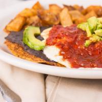 Huevos Rancheros · Two crispy tortillas topped with black beans, avocado, eggs over easy and ranchera sauce, se...