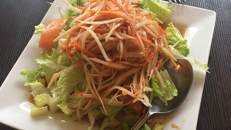 Papaya Salad · Shredded green papaya and carrots tossed with tomatoes, ground peanuts seasoned with lime juice.