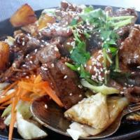 Sizzling Beef · Tender slices of beef seasoned with pineapple, ginger and sesame oil served over a bed of ca...