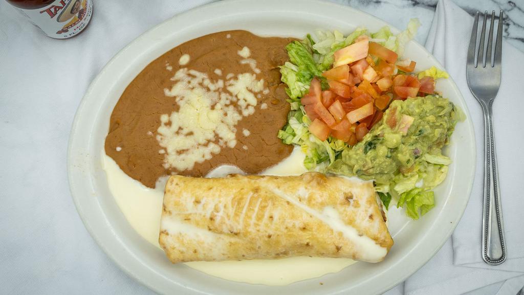Chimichanga · A flour tortilla deep fried and filled with beef tips, topped with nacho cheese. Served with beans and guacamole salad.
