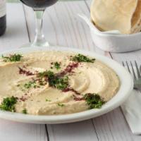 Hummus · Blended garbanzo beans with tahini, lemon juice and garlic. Served with warm pita for dipping.