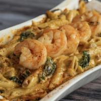 Bayou Shrimp Pasta · Creole shrimp, caramelized onions, tomatoes, collards and bacon crumbles in our creamy parme...