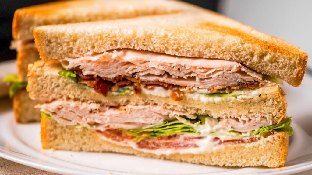 Turkey Club · Turkey, bacon, lettuce, tomato and mayo on triple deck of white toast.