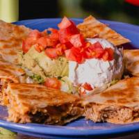 Chicken Quesadilla · Shredded chicken and cheese quesadilla garnished with lettuce, tomato, sour cream, and guaca...