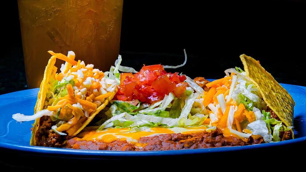 Taco Plate · Two hard shell beef tacos topped with lettuce, tomato, and cheese served with  rice and beans.